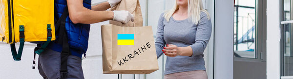 Мужчина держит в руках коробку помощи украинским беженцам и бедным гражданам, оказавшимся в войне между Украиной и Россией. Концепция гуманитарной помощи. Пожертвования для беженцев.