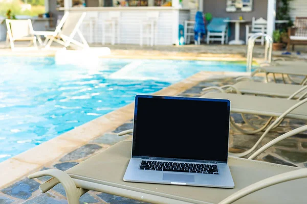 Laptop on a sun lounger by the pool — Stock Photo, Image