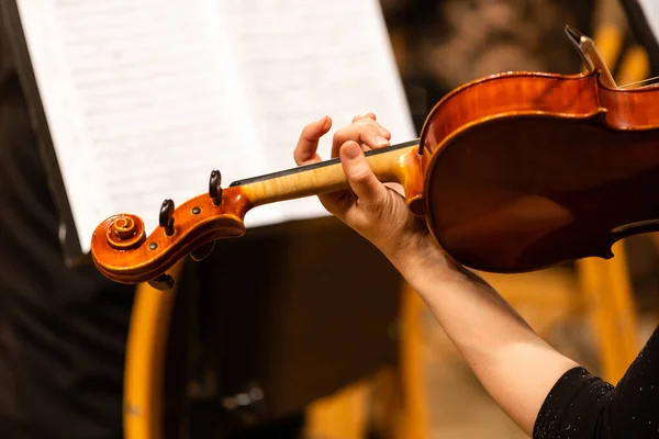 Orquesta sinfónica en el escenario, manos tocando el violín —  Fotos de Stock