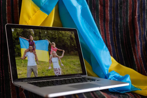 Nachrichten über die Ukraine auf dem Laptop. Flagge mit ukrainischem Hintergrund. — Stockfoto