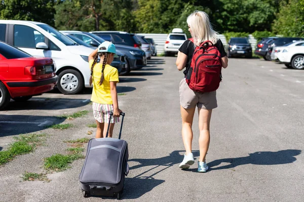 Mutter und Tochter mit Koffer auf dem Parkplatz — Stockfoto