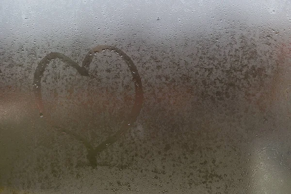Corazón en el cristal. corazón en una ventana de niebla — Foto de Stock