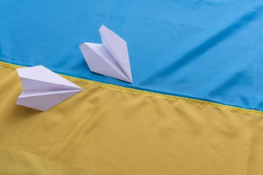 Ukrayna bayrağı taşıyan iki kağıt uçak. El yapımı sanat konsepti