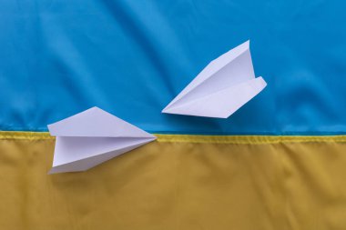 Ukrayna bayrağının arka planında kağıt uçak