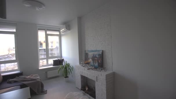 Interior del moderno loft cocina-estudio en el apartamento. Habitación, muebles, sofá cerca de la chimenea de madera — Vídeos de Stock