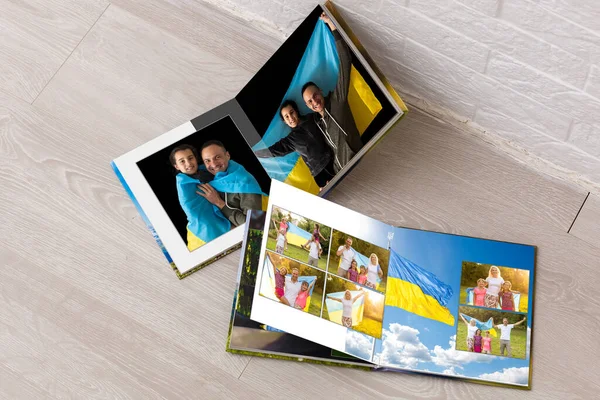 Fehér asztalon nyitott photobook fotózásról család ukrajnai zászló — Stock Fotó