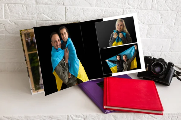 På vitt bord öppna fotobok från fotografering av familj med ukrainska flagga — Stockfoto