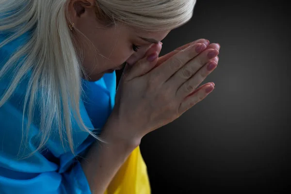 어두운 배경에서 옷을 걸치고 우크라이나 국기를 들고 있는 아름다운 젊은 여성 — 스톡 사진