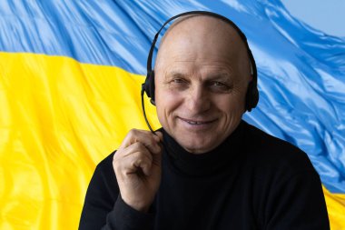 Ukrayna bayrağının arka planındaki mutlu genç adam..
