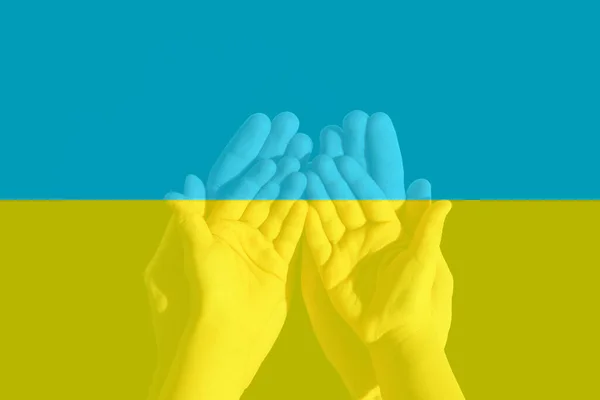 Be för Ukraina. hand i bön och den ukrainska flaggan i bakgrunden. — Stockfoto