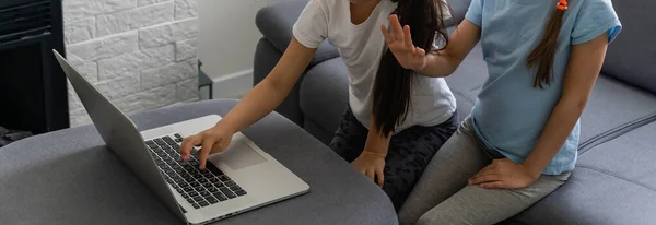 Duas meninas trabalhando no laptop, sorrindo e irmã mais velha ajudar mais jovem — Fotografia de Stock