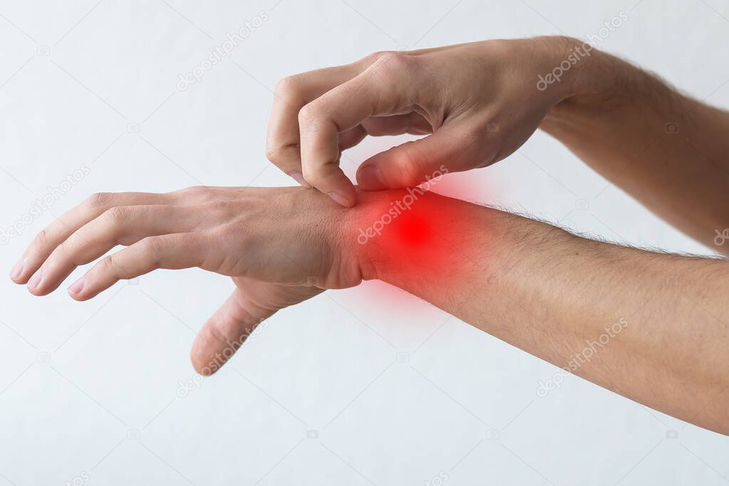 Dermatitis, eczema, allergy, psoriasis concept. man scratching itch on his arm, grey studio background. man itching rash on his elbow, copy space