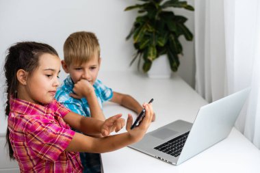 Tatlı çocuklar eğitim için dizüstü bilgisayar, online çalışma, evde öğrenim, uzaktan öğrenim gören kız ve erkek çocukları. Evde eğitim için yaşam tarzı kavramı.