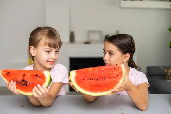 Funny little sisters eating fresh juicy watermelon at home — Stock Photo, Image