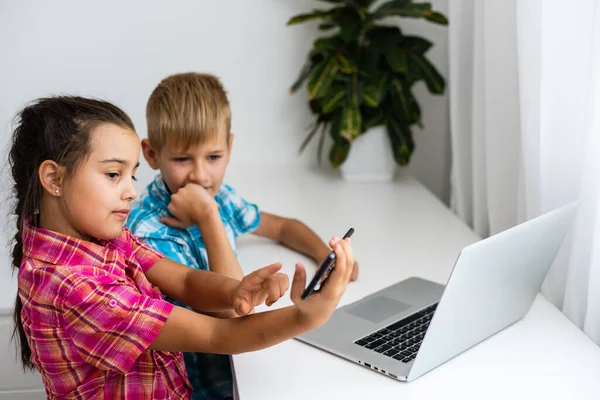 I bambini svegli usano il computer portatile per l'istruzione, lo studio online, lo studio a casa, Boy and Girl hanno compiti a distanza. Concetto di stile di vita per la scuola a casa. — Foto Stock