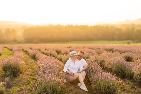 魅力的な女性が新鮮なラベンダー畑に横たわっているハンサムな男,お互いを楽しんで,ロマンチックな関係,愛の概念 — ストック写真