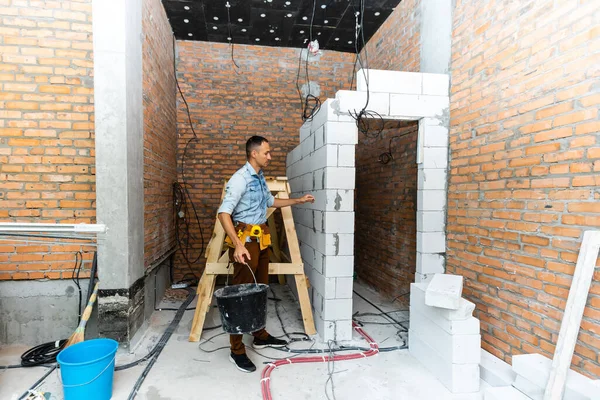 Repairman inside a house under construction. construction worker. Career as apartment renovator. — ストック写真