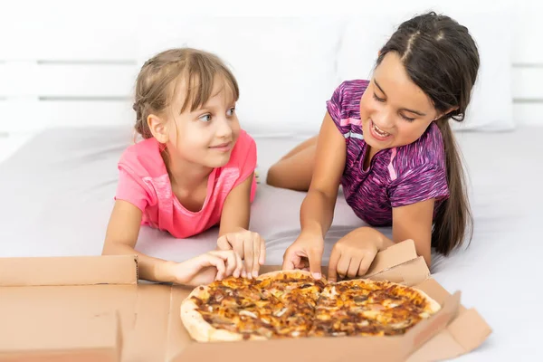 Pizza kutularıyla poz veren çekici küçük kızlar.