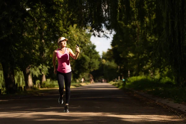 Fitness sportos nő futó vidéki természetben zenét hallgatni — Stock Fotó