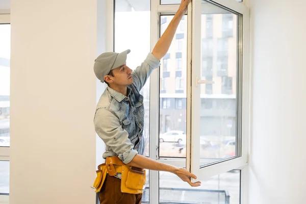 Byggnadsarbetare montera fönster i huset — Stockfoto