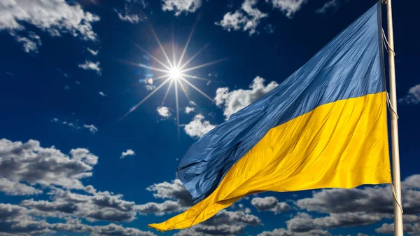 Duża flaga narodowa Ukrainy wznosi się na błękitnym niebie. Wielki żółty sztandar ukraińskiego państwa. Niepodległość, flaga, Dzień Konstytucji, Święto Narodowe, przestrzeń tekstowa. — Zdjęcie stockowe