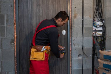 İşçi inşaat kutusunda aletler buluyor. Çalışma sahasında, şantiyede..