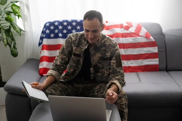 미국 국기 근처에서 노트북을 보고 있는 애국 군인 — 스톡 사진