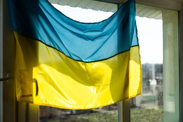 Unterstützt die Ukraine. Ukrainische Flagge am Fenster. Platz für Text. — Stockfoto