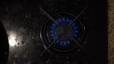 Mutfak ocağının tepesinden yakın çekim mavi ateş. Gaz ocağı ve propan gazı alevleri. Sanayi kaynakları ve ekonomi kavramı