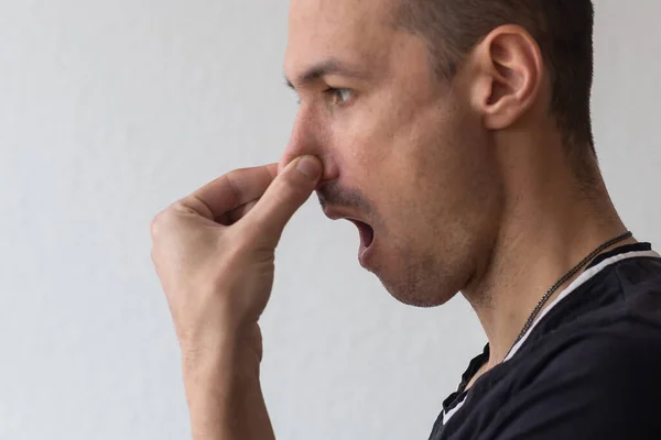 Adam, pis bir koku ve kötü koku burnundaki pinches — Stok fotoğraf