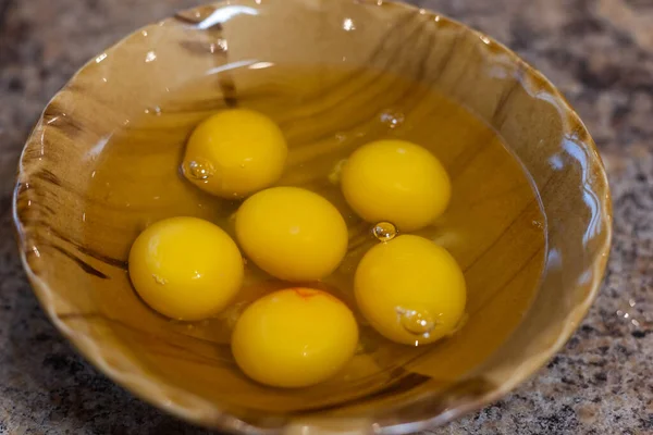 Крупный план миски с разбитыми куриными яйцами на кухонном столе — стоковое фото