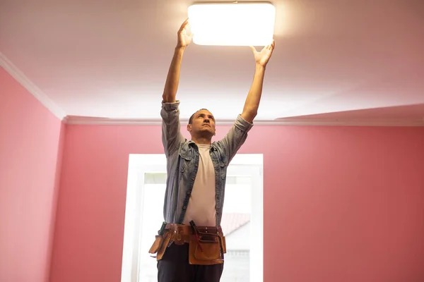 Eletricista verificando iluminação para o teto em casa, conceito técnico — Fotografia de Stock