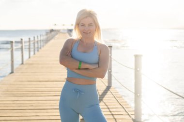 Genç bir kadın güneşli bir günde denizin önünde dubada