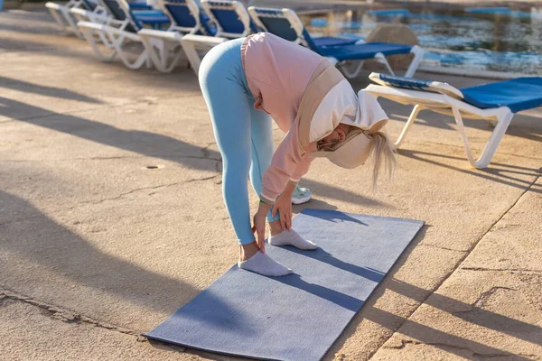 Фитнес-атлет женщина делает упражнения на растяжку под открытым небом тропический бассейн Вилла двор, Раннее утро Отдых в отеле, Здравоохранение, благополучие — стоковое фото