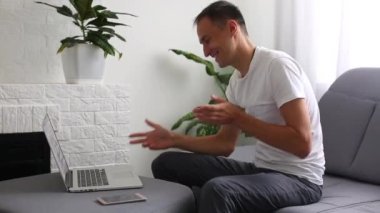 Mutlu adam evde bir dizüstü bilgisayarda çalışan