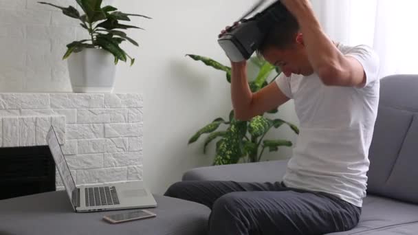 Δημιουργικός νεαρός προγραμματιστής χρησιμοποιεί γυαλιά εικονικής πραγματικότητας ενώ κάθεται — Αρχείο Βίντεο