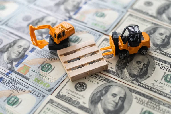 Equipamento de construção de brinquedos constrói uma nova estrada a partir de notas de dólar. — Fotografia de Stock