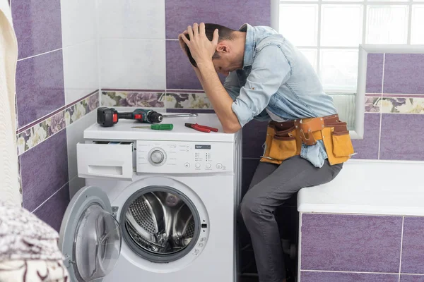 Operaio idraulico ripara una lavatrice in lavanderia — Foto Stock