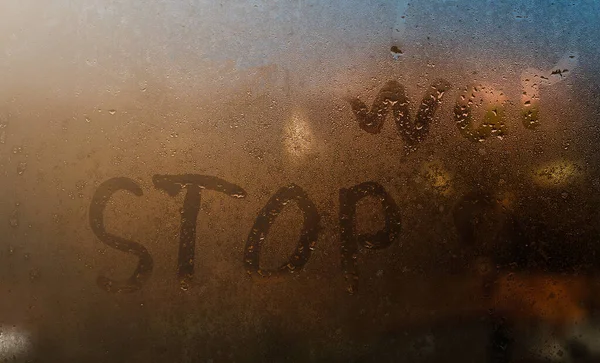 La palabra parada escrita en la noche ventana húmeda de vidrio de primer plano con fondo borroso — Foto de Stock