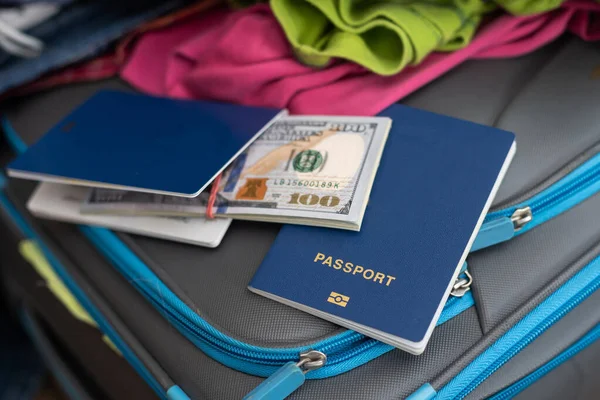 Mala. roupas espalhadas, passaporte, dinheiro — Fotografia de Stock