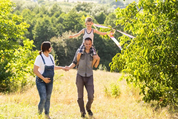 어린 부모들은 아들을 데리고 밀 밭으로 간다. 놀고 있으면 행복해 하는 어린 아들. — 스톡 사진
