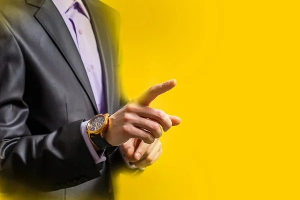 People, business and gesture concept - close up of man pointing finger to something yellow background — стоковое фото