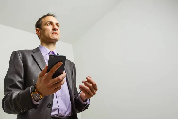 Der Geschäftsmann an einer grauen Wand — Stockfoto