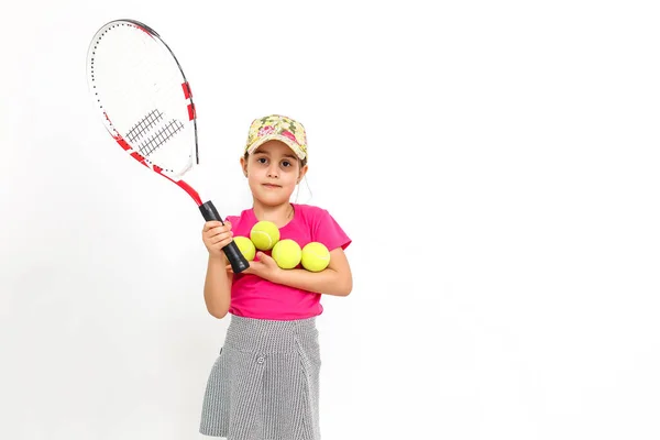 Menina bonito com raquete de tênis em suas mãos no fundo branco — Fotografia de Stock