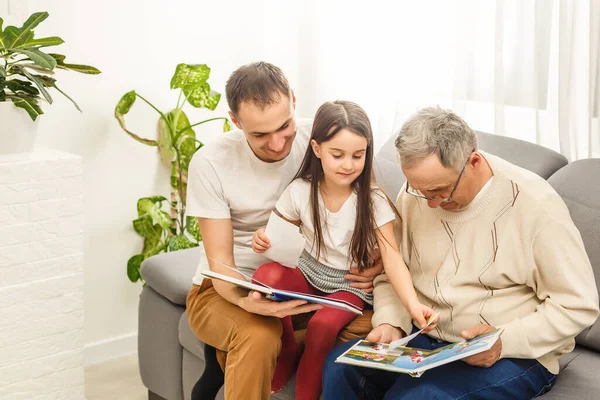 Famille regardant un album photo dans le salon — Photo