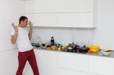 Kirli aletleri mutfak lavaboda yakınındaki bakarak üzgün genç adam.