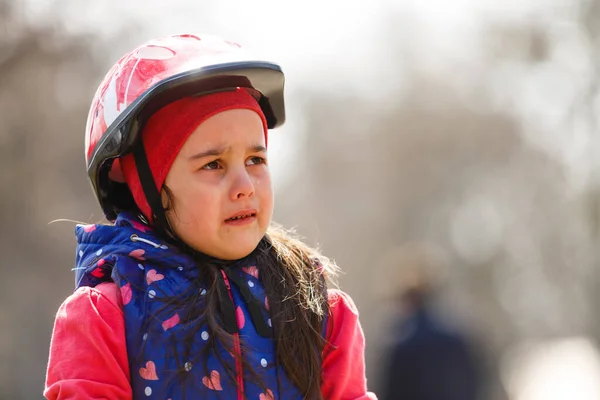 Красива брюнетка маленька дівчинка в велосипедному шоломі і відбиваючому жилеті з сумним виразом плаче. концепція депресії . — стокове фото