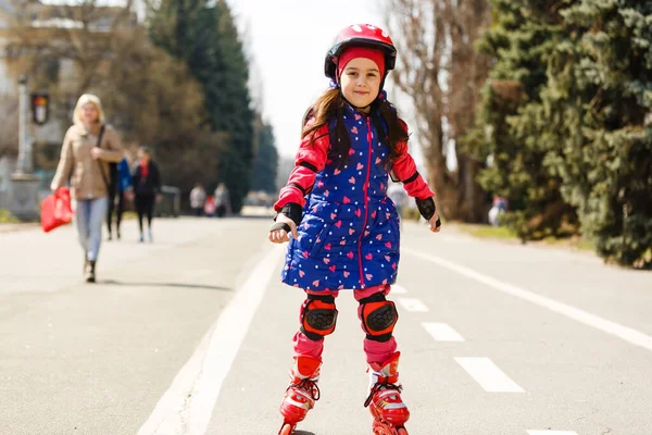 공원에서 헬멧에 롤러 스케이트에 예쁜 소녀 — 스톡 사진
