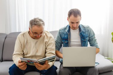 Ebeveynler ve oğulları birlikte evdeki fotoğraflara bakarlar.