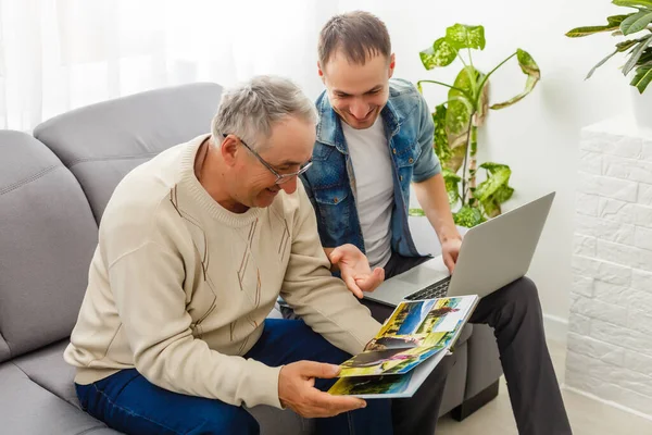 Genitori e figlio insieme guardano le foto nel fotolibro a casa — Foto Stock